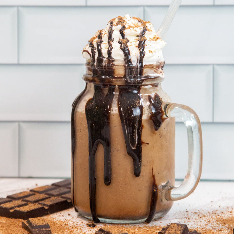 Frozen hot chocolate in a handled glass with whipped topping and chocolate drizzle