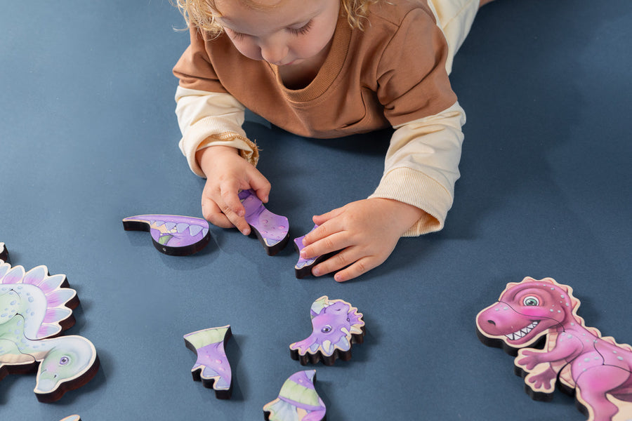 Children assembling small dinosaur-themed magnetic wooden puzzles