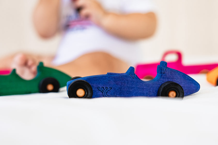 Colorful wooden Indy-style toy cars arranged for racing play