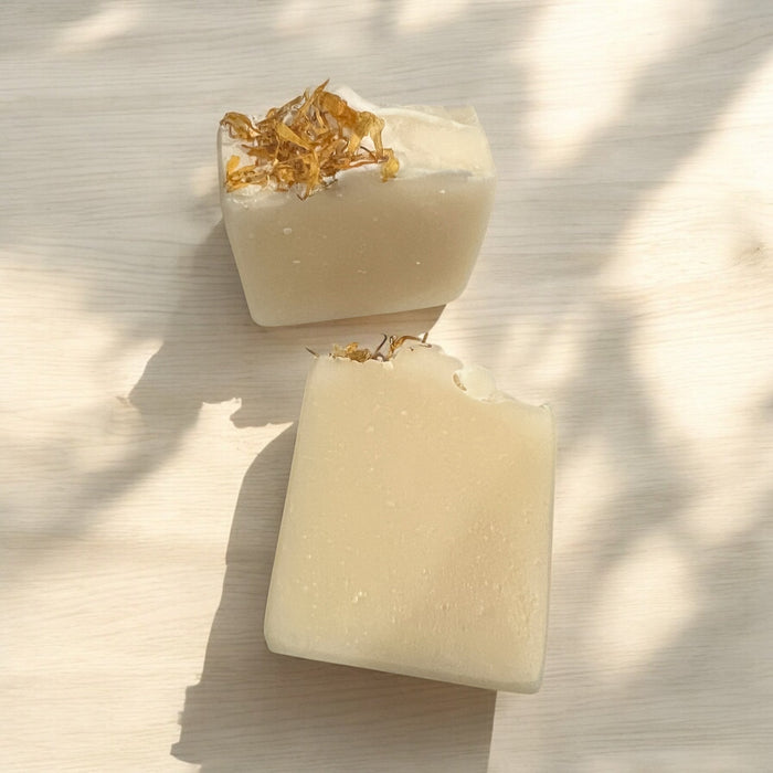 Two pale Scent of Solace handmade soap bars in sunlight