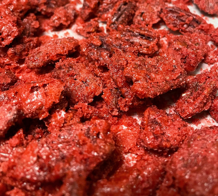 Close-up of Red Velvet candied pecans with a red textured coating