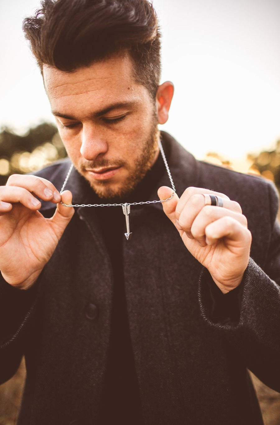 Model holding an Arrow of Courage necklace