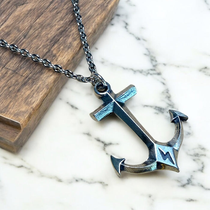 Hold Fast Anchor pendant and chain on pale stone and wood