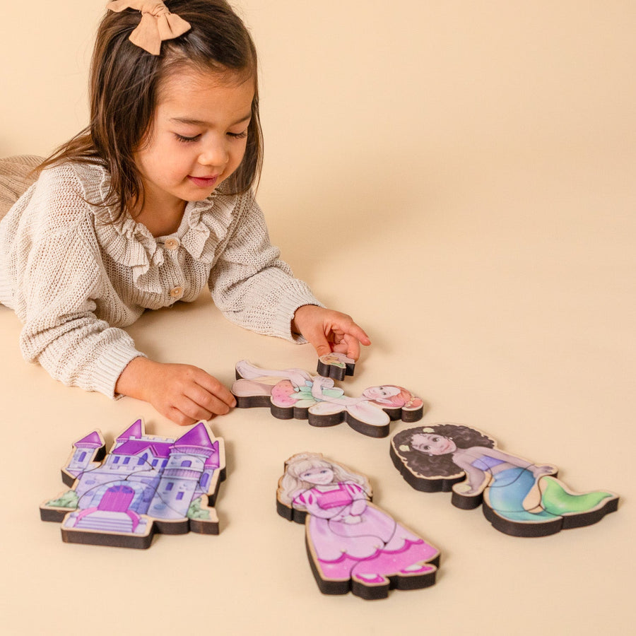 Child assembling small fairytale-themed magnetic wooden puzzles