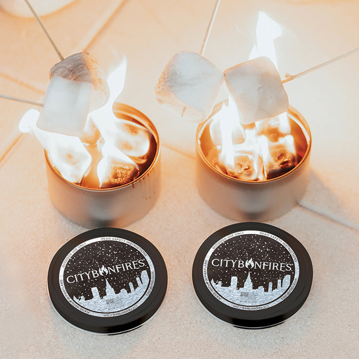Two lit portable bonfires with marshmallows roasting above them