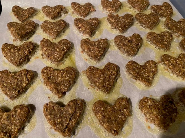 Heart-shaped pet cookies arranged on a baking sheet