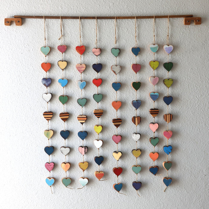 Hanging strands of wooden hearts in varied painted and natural colors.