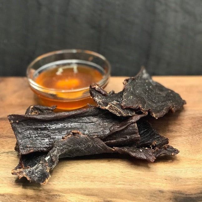 Honey Buffalo Jerky, dried strips beside a bowl of honey