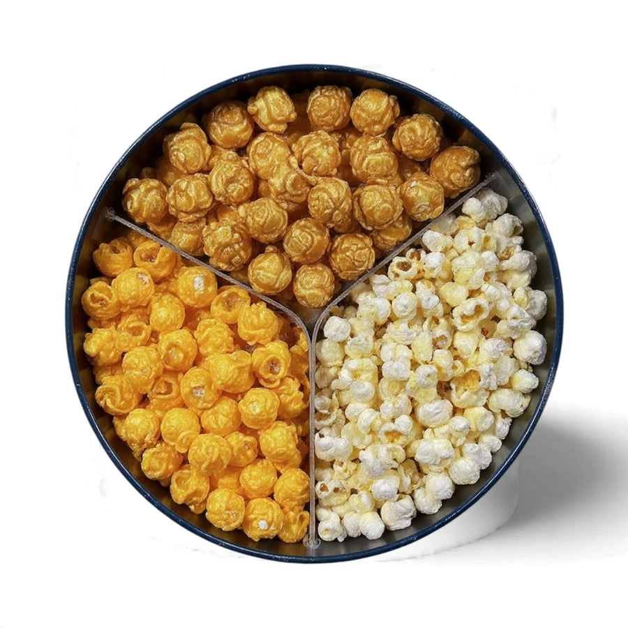 Open tin with caramel, white cheddar, and cheddar popcorn compartments