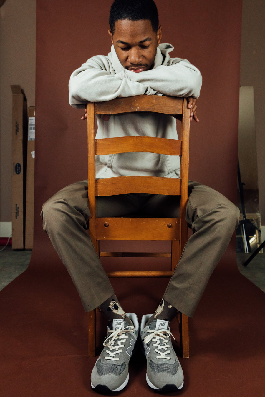Cream glazed cotton shoelaces worn with gray high-top sneakers while seated