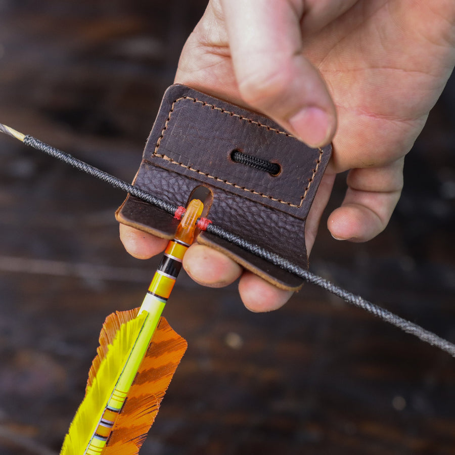 Split-Finger Leather Archery Tab — leather tab held behind nocked arrow