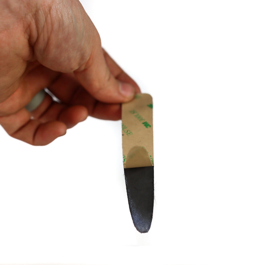 Peel-and-Stick Calf Hair Recurve String Groove Silencers — adhesive backing being peeled from a pad