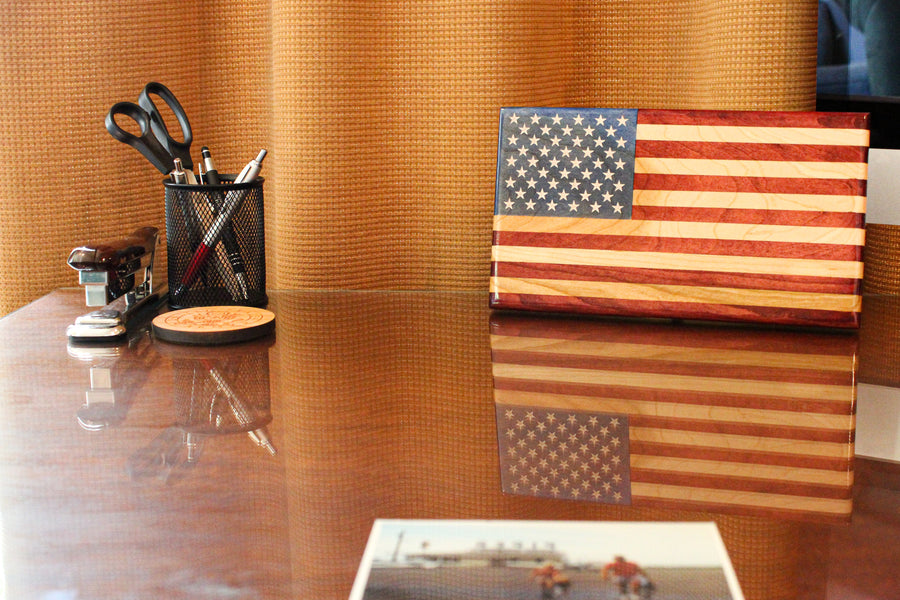 Young Glory wooden desktop flag standing on a polished desk