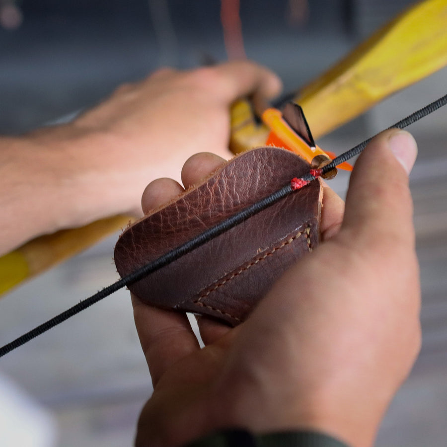 YES Tab 3-Under Archery Finger Tab — tab held against the bowstring