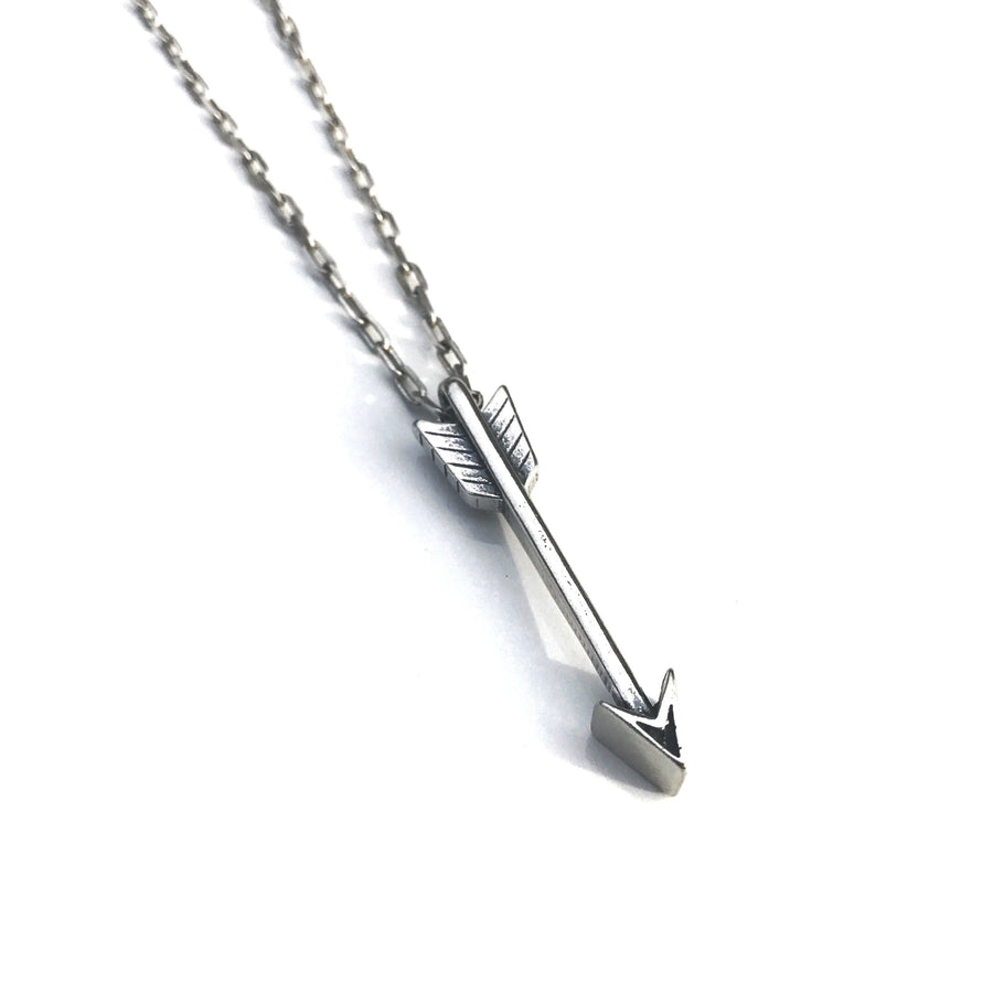 Arrow necklace and chain against a light background