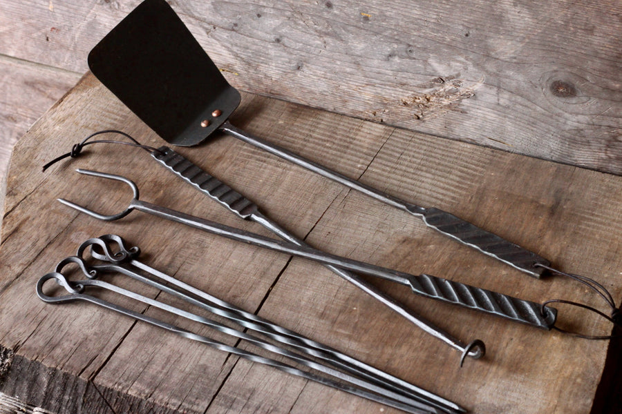 Pigtail meat flipper pictured with matching grilling tools