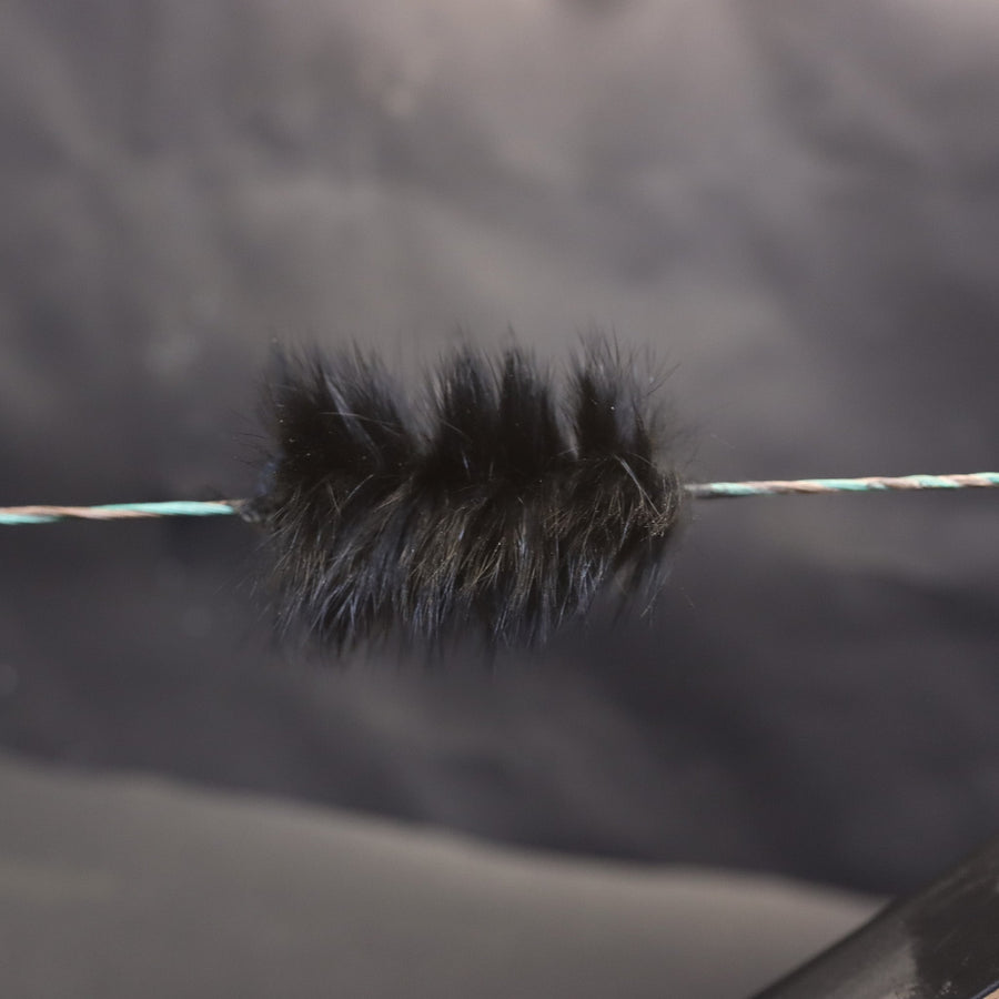 Black Rabbit Fur Bowstring Silencers — installed fur silencer against a gray background