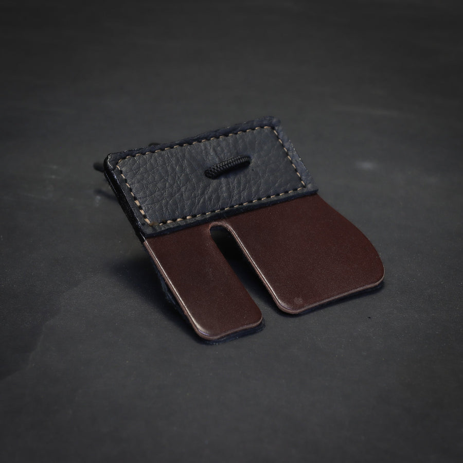 Shell Cordovan Split-Finger Archery Tab — split-finger cordovan tab laid on bench