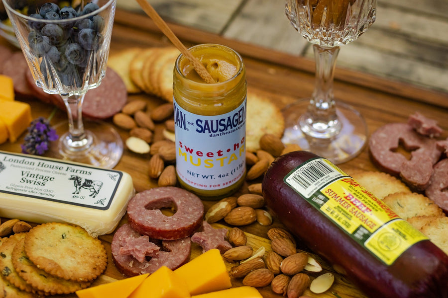 Sausage, cheese, crackers and nuts beside a Sweet Hot Mustard jar; serving suggestion