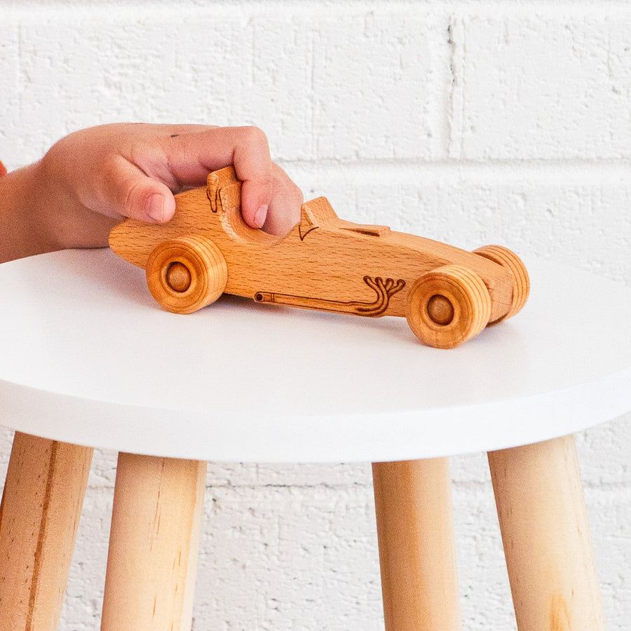 Child’s hands holding and guiding a wooden toy airplane