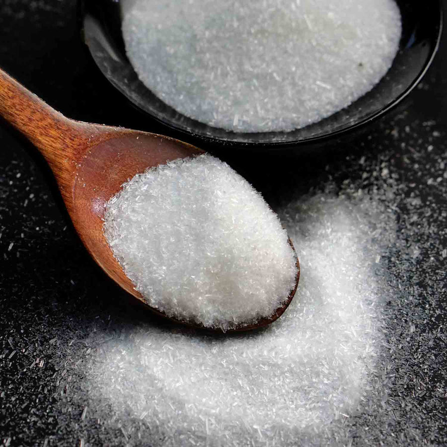 Allulose Plus Granulated Sweetener: granulated sweetener on spoons.