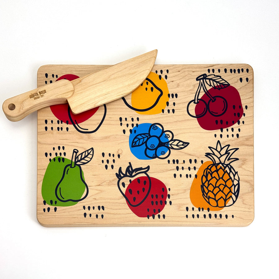 Fruit-illustrated wooden cutting board with wooden knife resting on it
