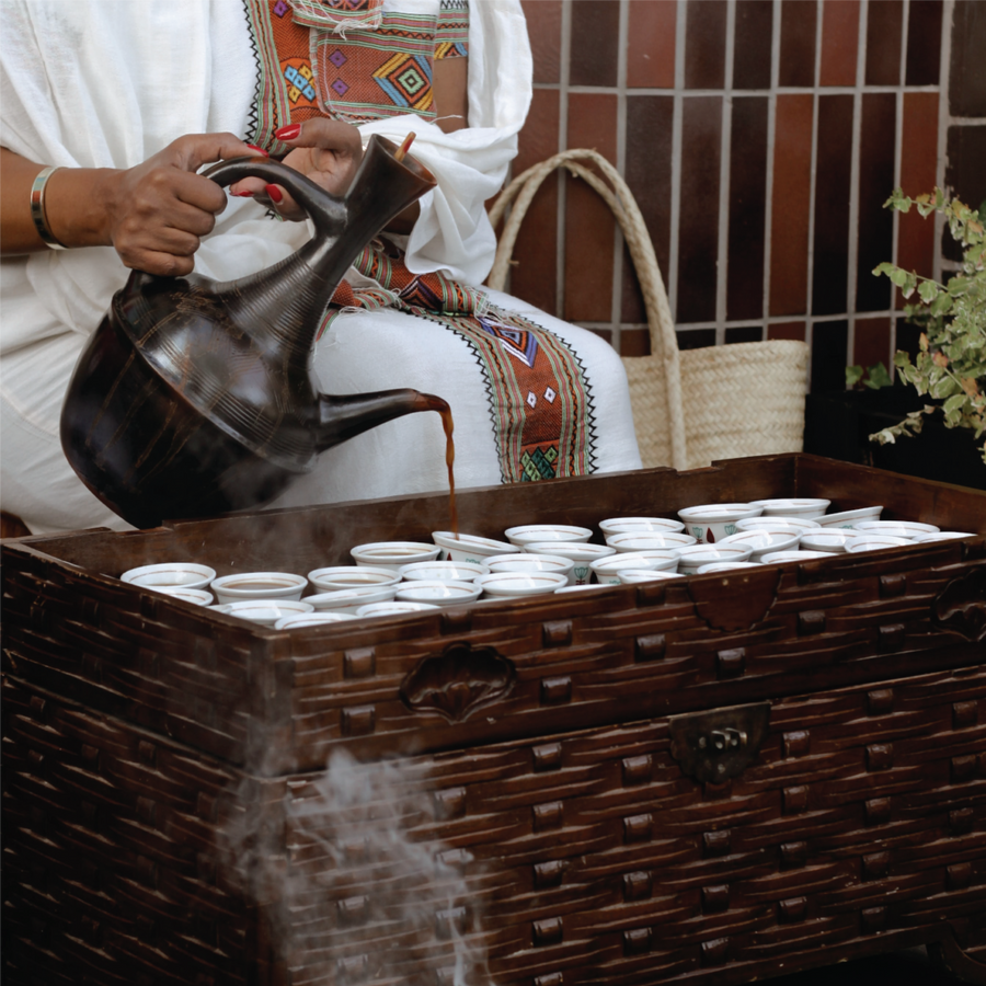 Coffee being poured into small cups during a coffee service