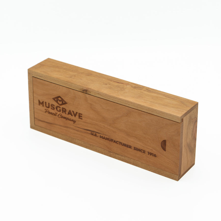 Cherry wood pencil box standing on its side with engraved branding