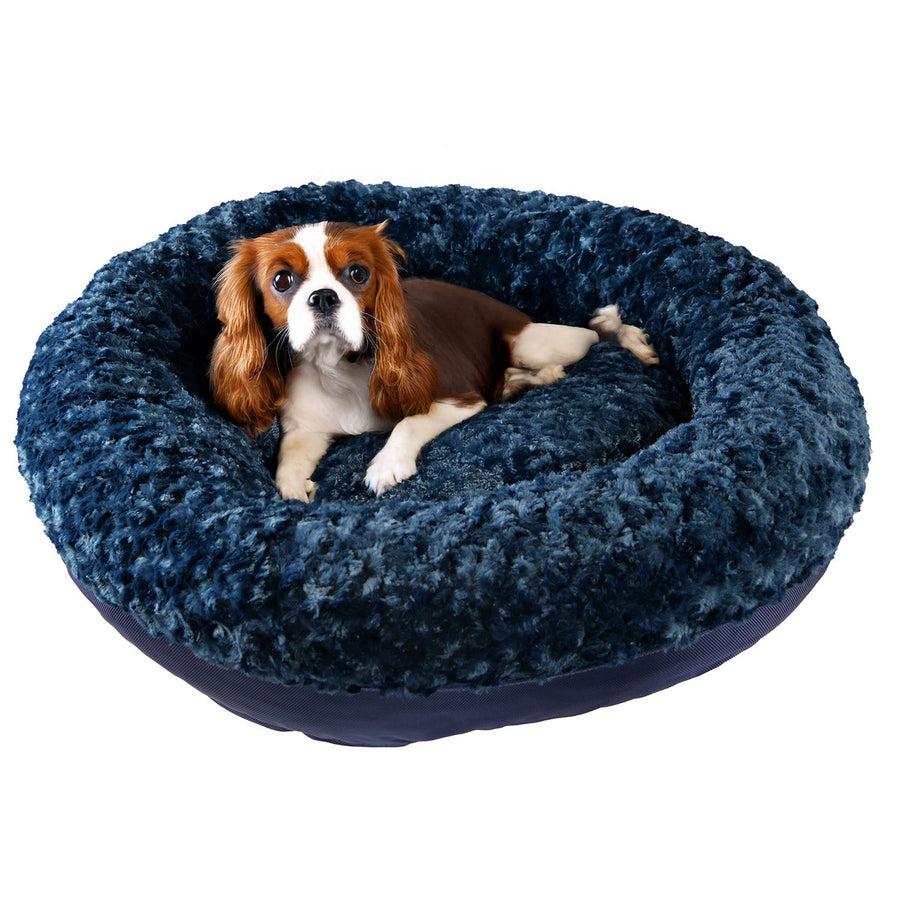 Dog resting in a midnight blue Furvana round bolster dog bed