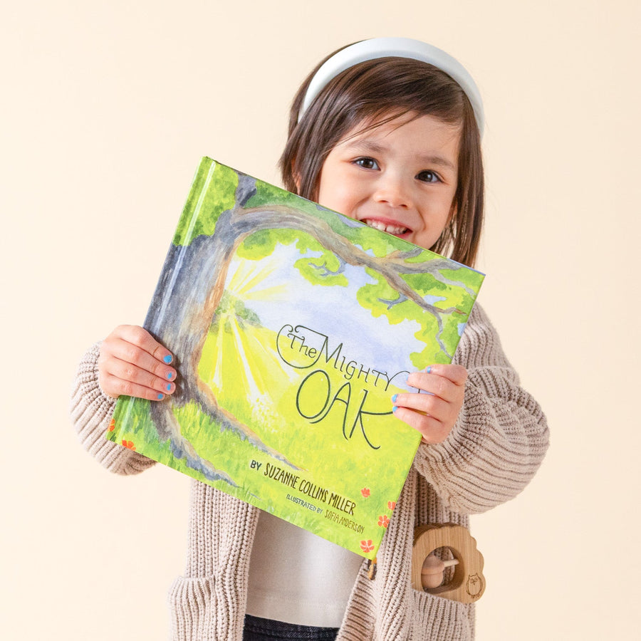 Child holding The Mighty Oak children’s book