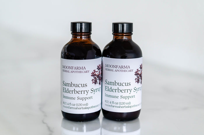 Two amber bottles of Sambucus elderberry syrup