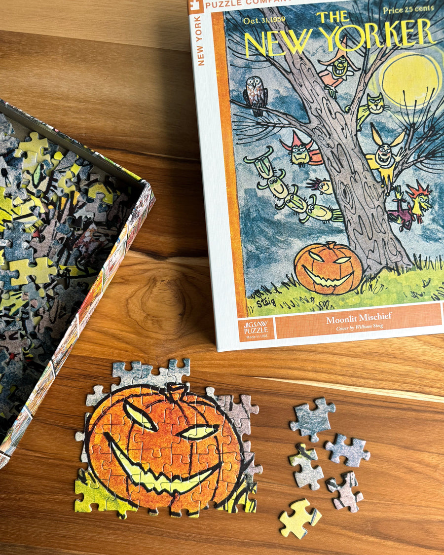 Moonlit Mischief puzzle with loose pieces in a styled photograph