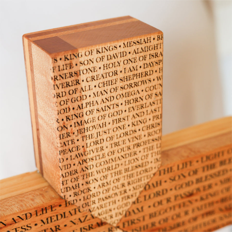 Reclaimed piano wood cross engraved with names of the Savior.