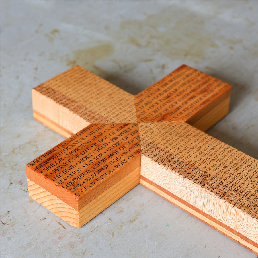 Reclaimed piano wood cross engraved with names of the Savior.