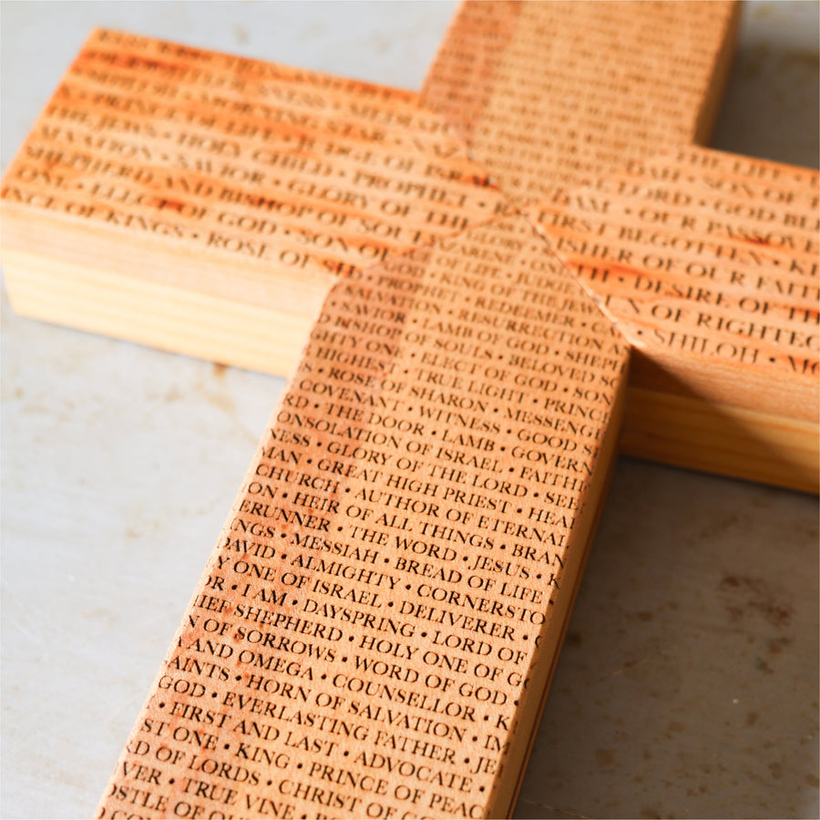 Reclaimed piano wood cross engraved with names of the Savior.