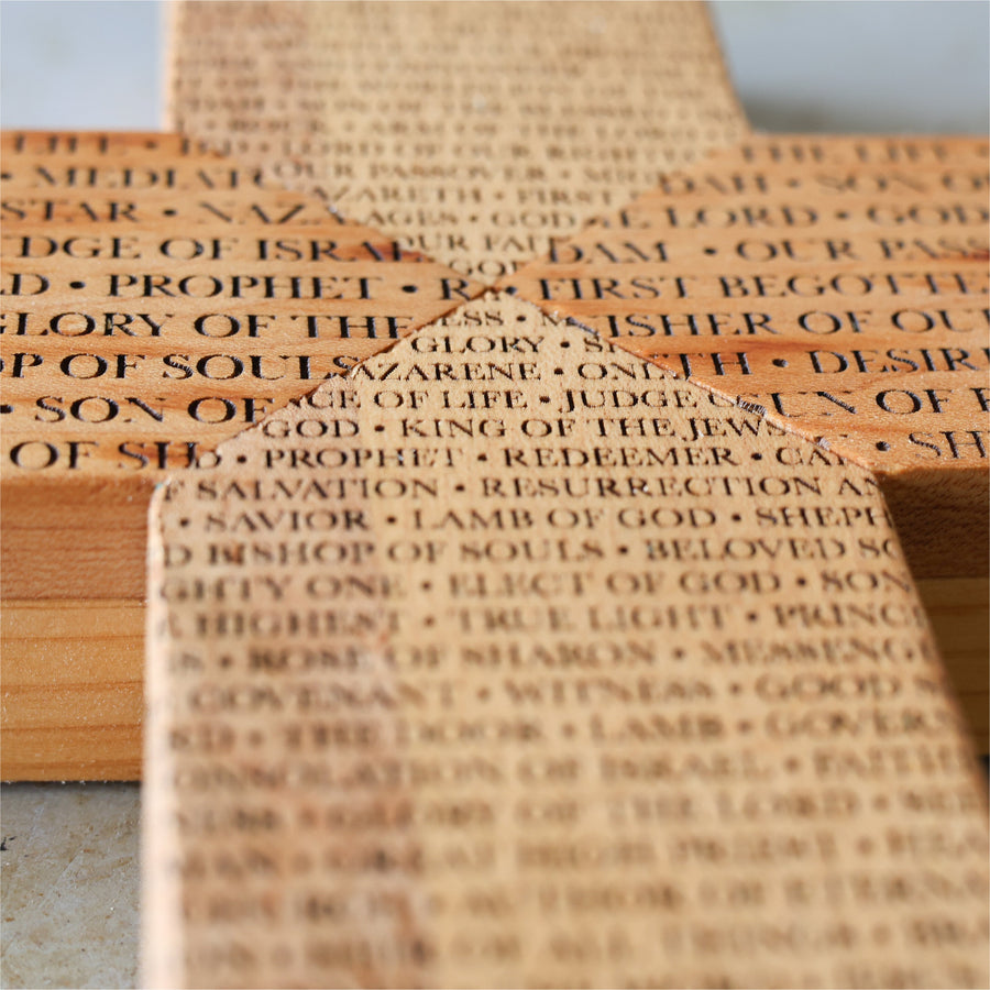 Reclaimed piano wood cross engraved with names of the Savior.