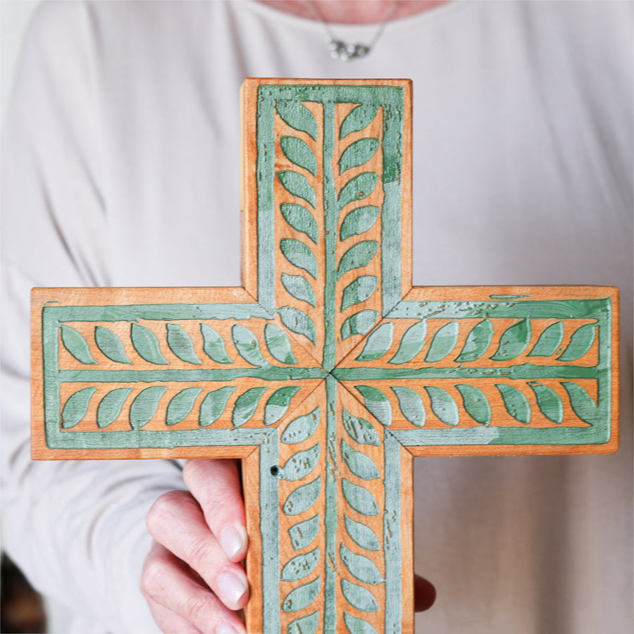 Piano wood cross engraved and painted with a turquoise vine illustration.
