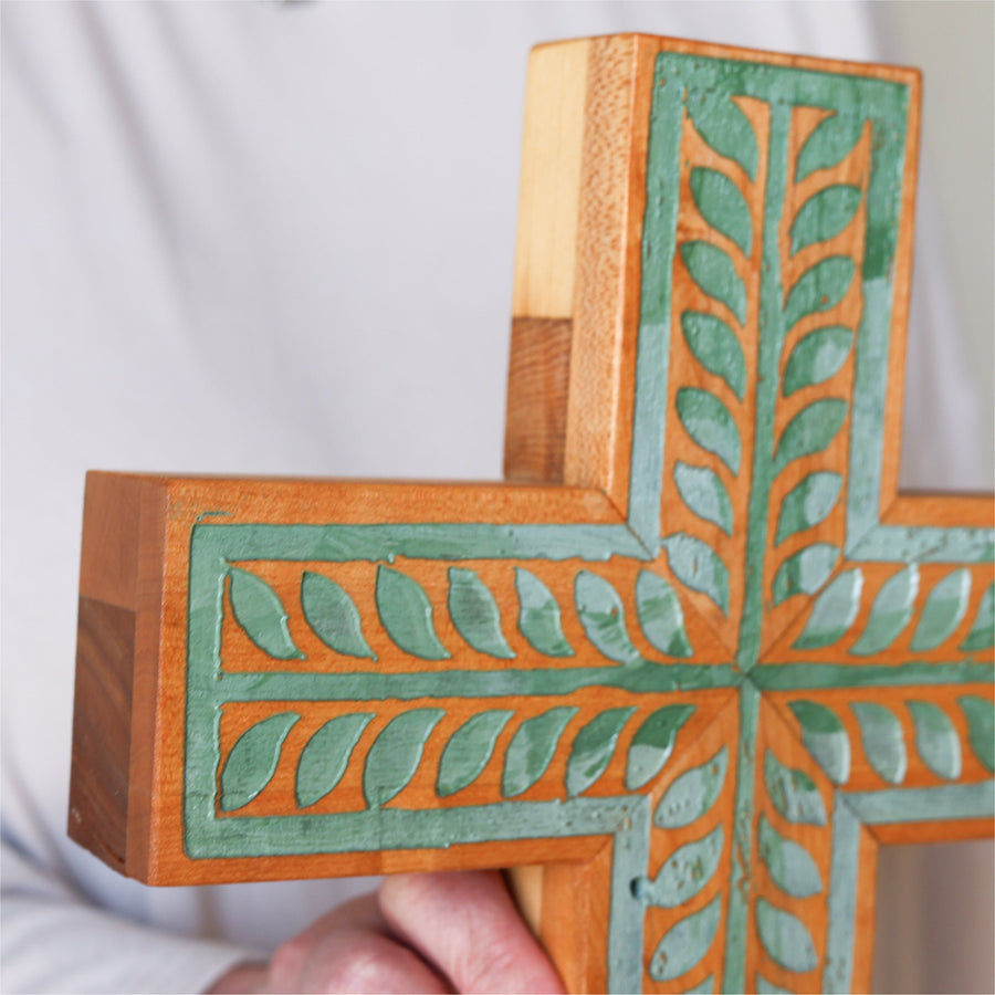 Piano wood cross engraved and painted with a turquoise vine illustration.