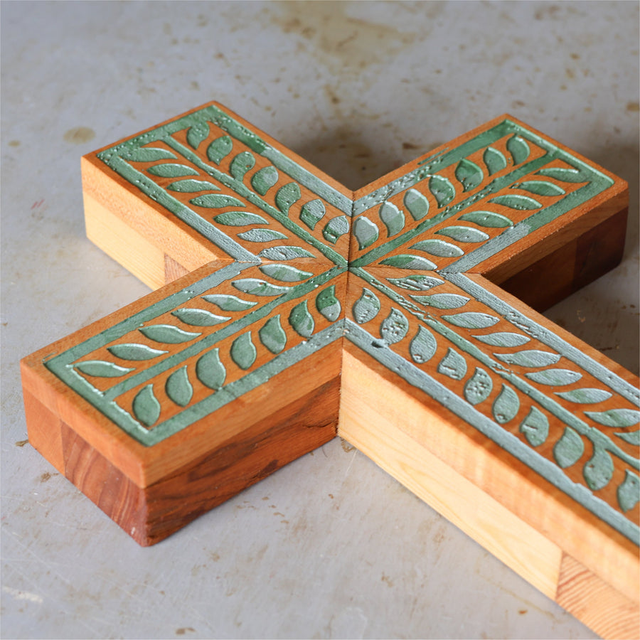 Piano wood cross engraved and painted with a turquoise vine illustration.