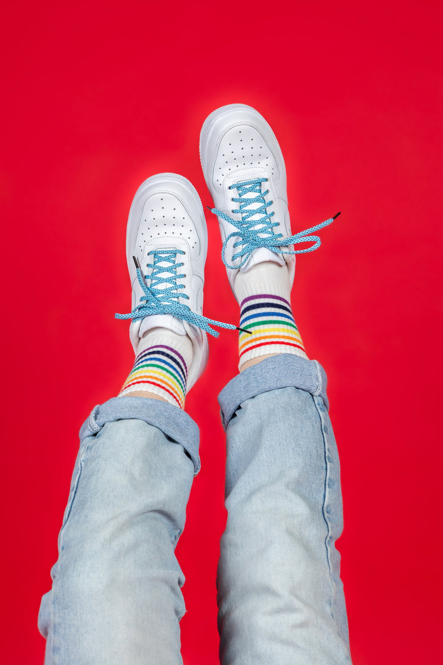 Light Blue & Black ticked flat shoelaces worn with white sneakers and rainbow-striped socks