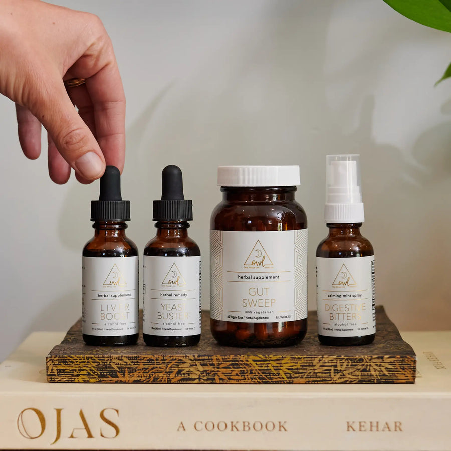 Four OWL supplement bottles arranged on a cookbook