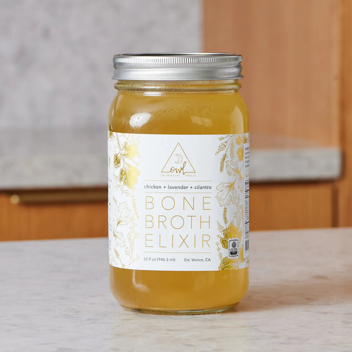 Organic chicken bone broth in a labeled glass jar on a kitchen counter