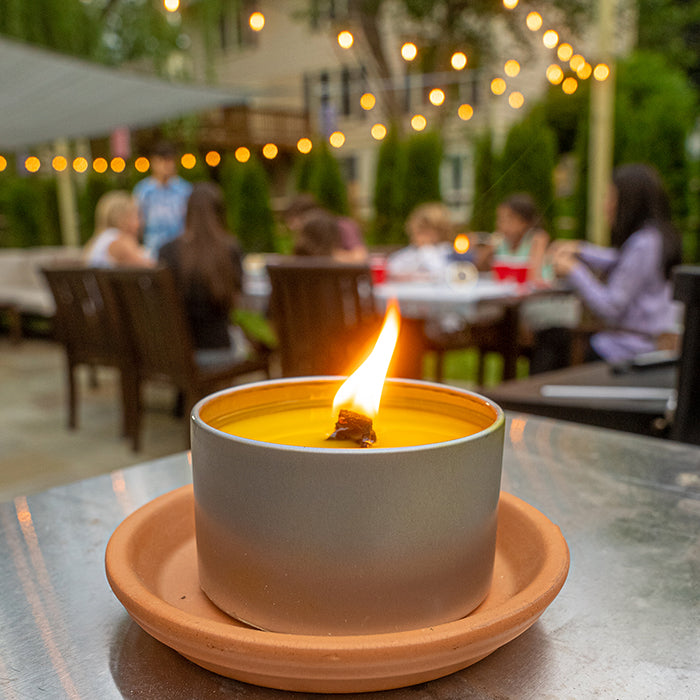 Lit citronella candle in an outdoor evening setting
