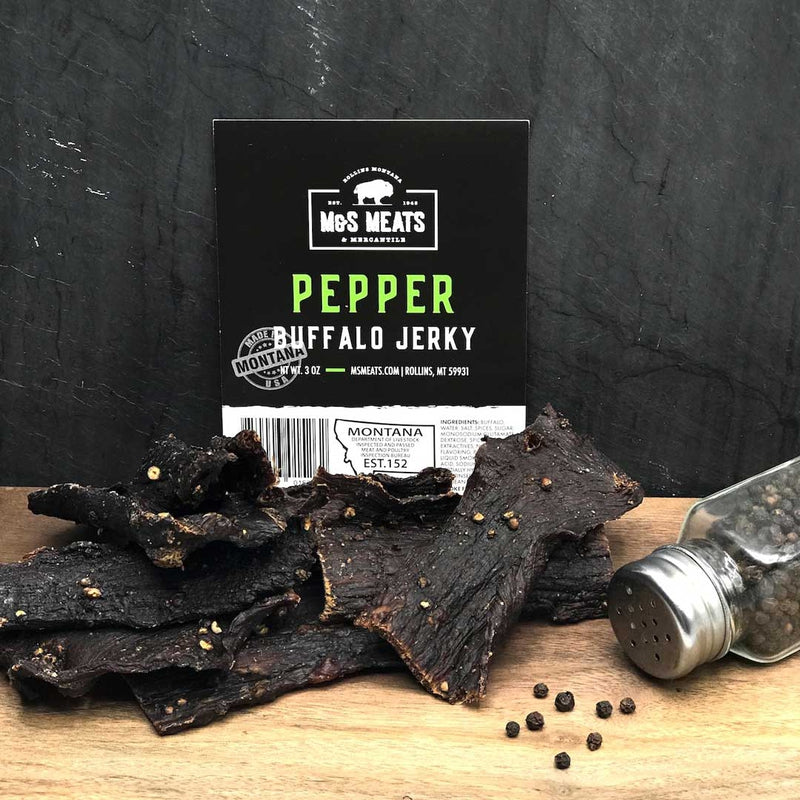 Pepper Buffalo Jerky, strips beside a pepper shaker and display card
