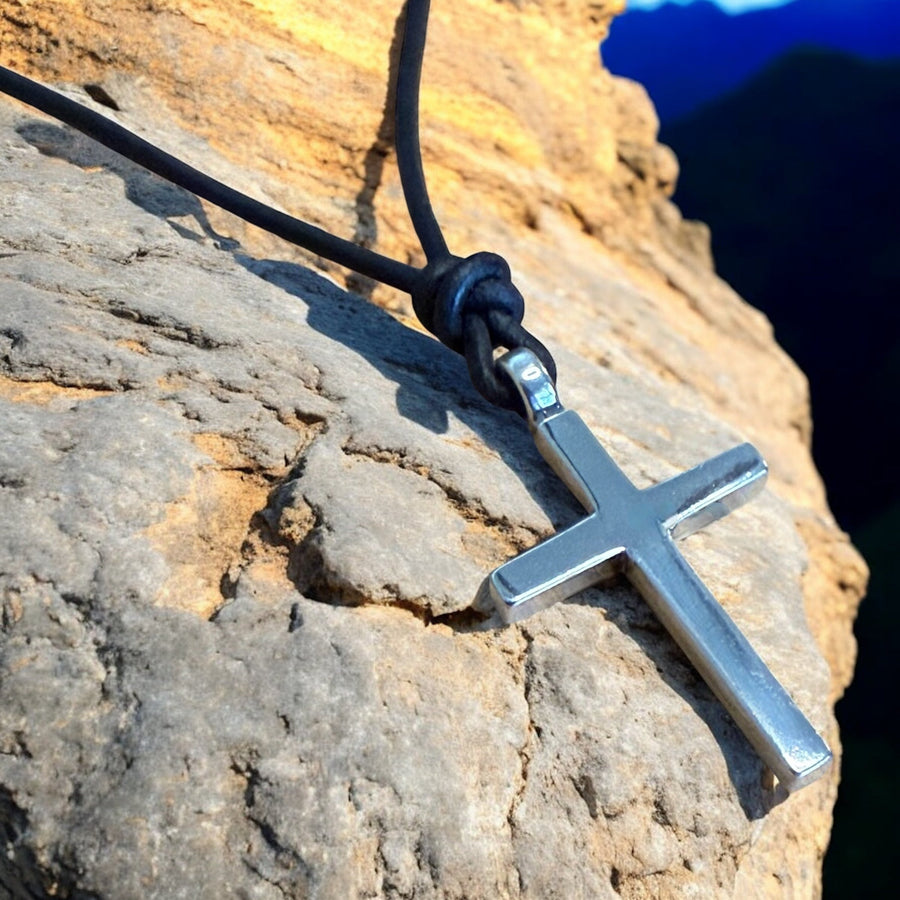 Classic cross pendant resting on layered rock