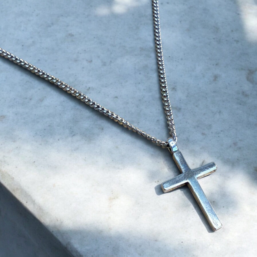 Close view of Classic Cross pendant against pale stone