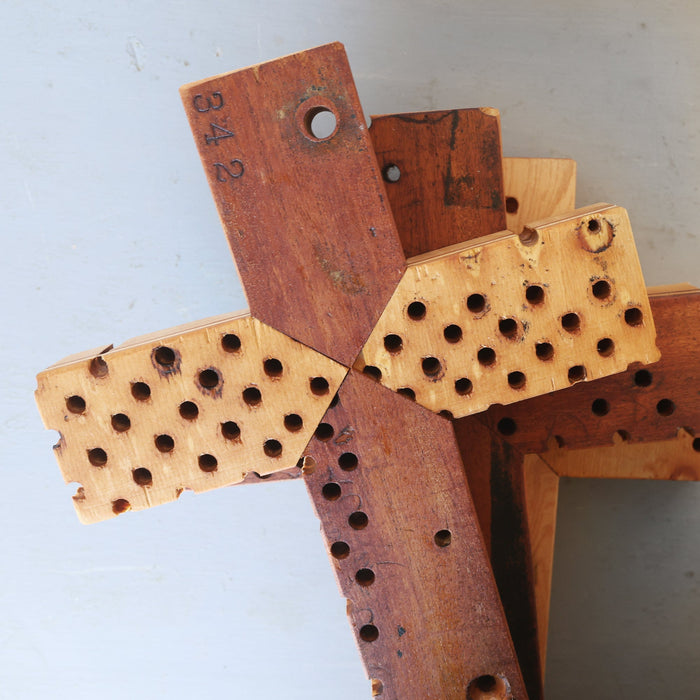 Reclaimed piano wood cross with original holes and aged surfaces.
