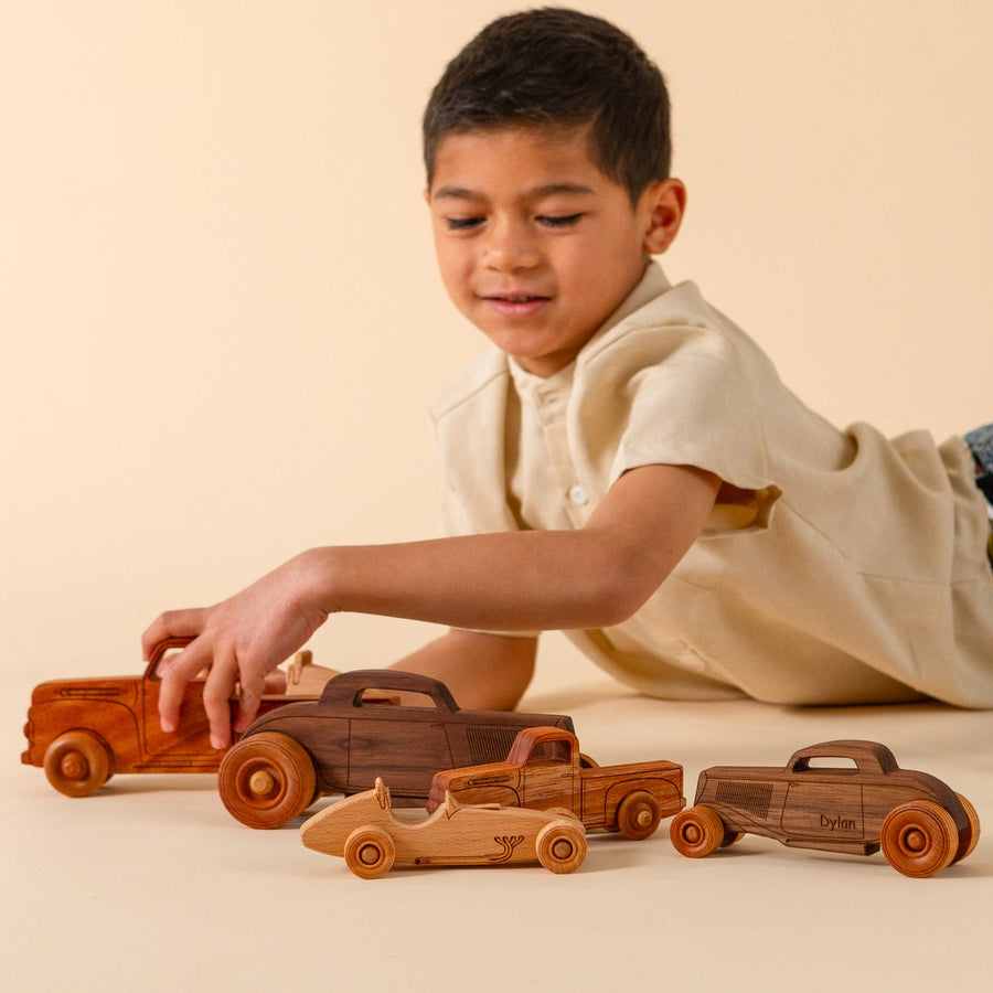 Children playing with an assortment of wooden cars, trucks and airplanes