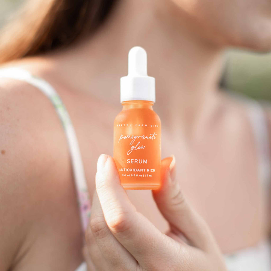 Person holding Pomegranate Glow facial serum