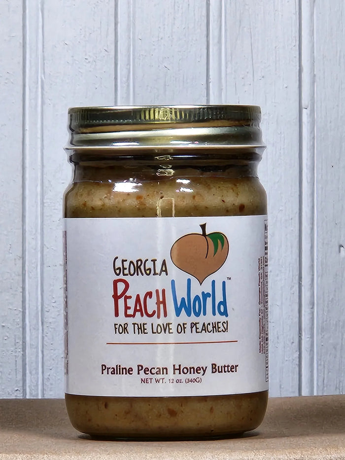 Praline pecan honey butter in a glass jar with a gold lid.